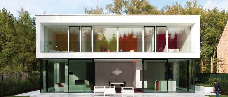 Witte luxe villa met groene tuin.