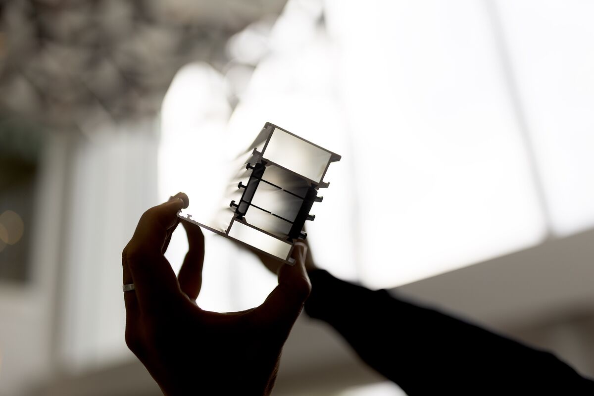 Ombre d’un profilé en aluminium isolé, tenu par deux mains.