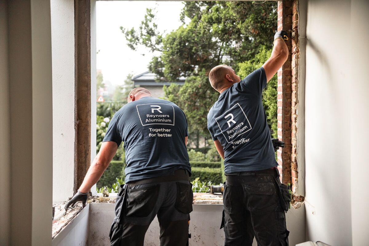 Twee Reynaers Aluminium Installers demonteren oude ramen op locatie.