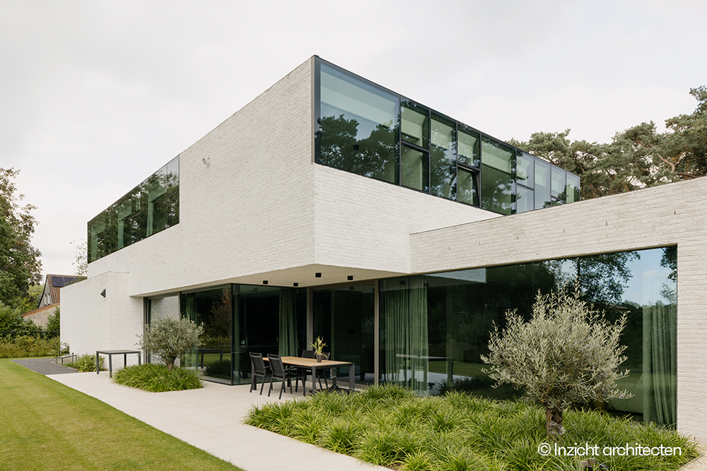 Moderne witte BEN-woning met zwarte ramen van Reynaers Aluminium uitgerust met driedubbel glas