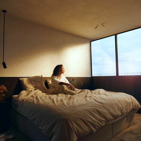 Woman in bed looking through aluminium window