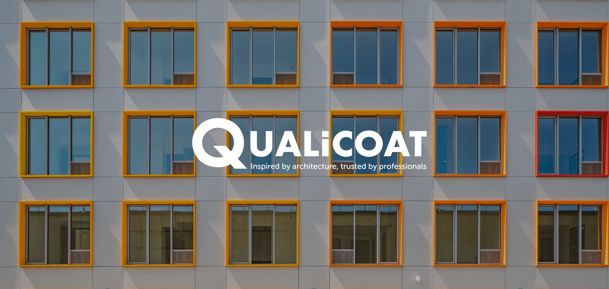 Logo Qualicoat devant des fenêtres colorées.