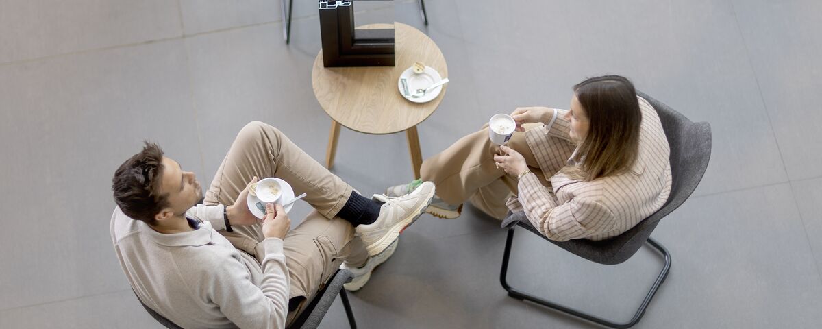 Vue de dessus : homme et femme assis à table en train de boire du café.